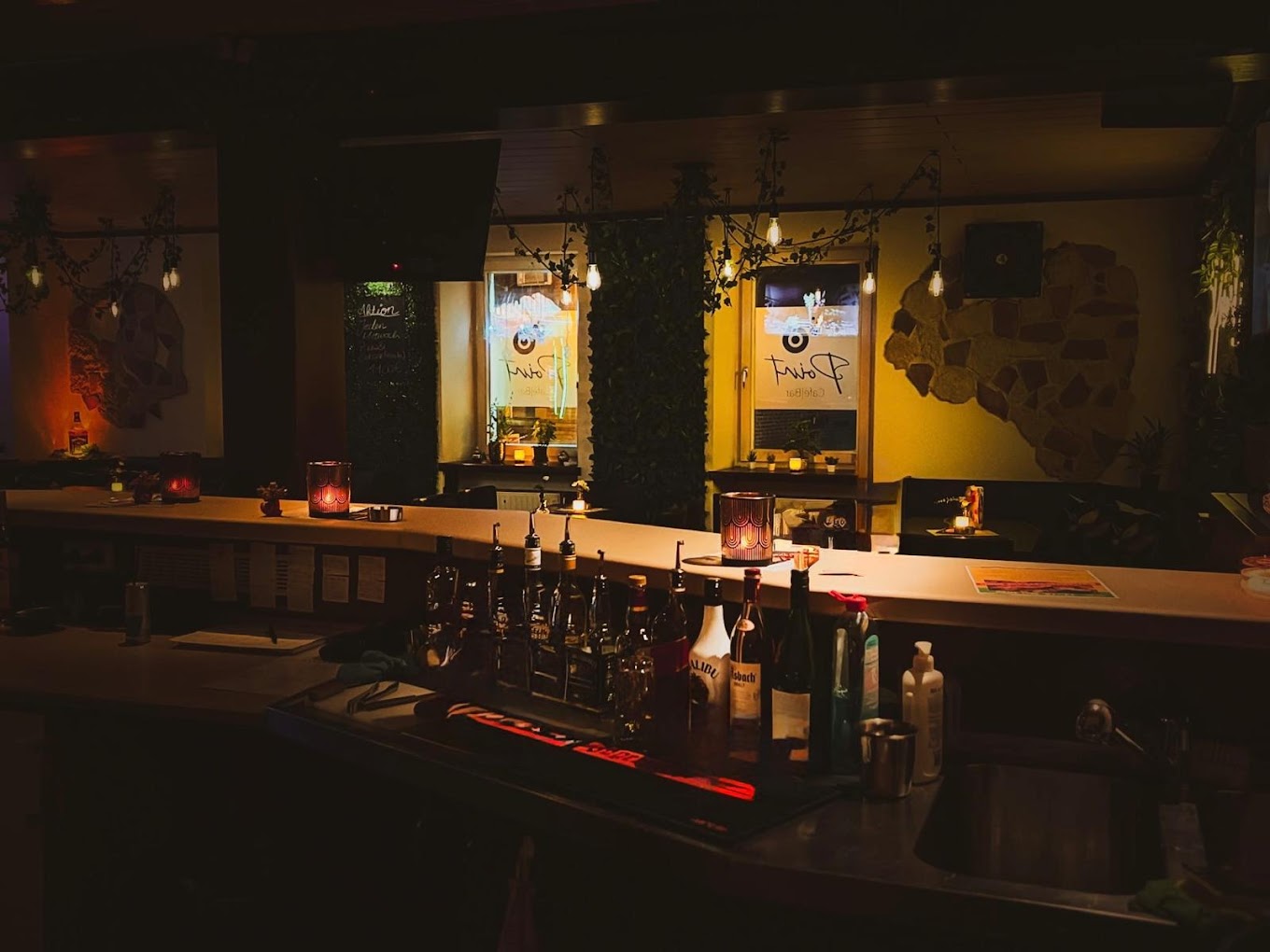 Bar-Tresen im Point Cafe Bar mit Spirituosen und warmer Beleuchtung