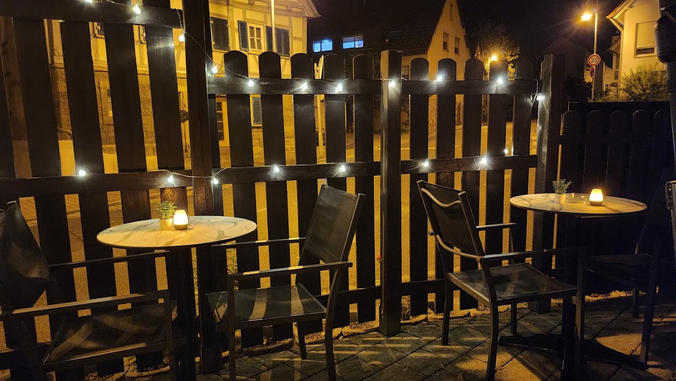 Außenbereich des Point Cafe Bar am Abend mit Lichterketten
