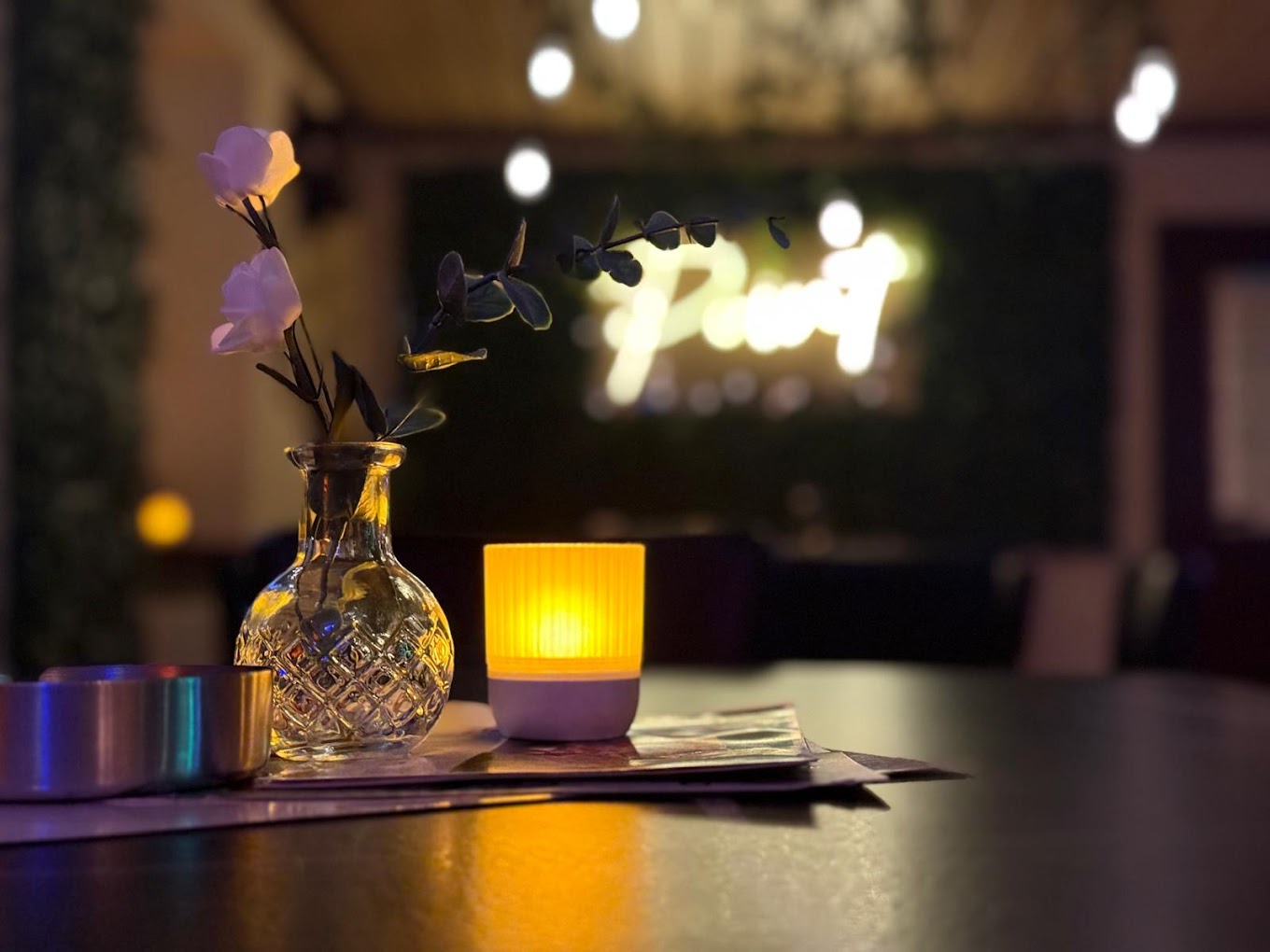 Tischdetail mit Kerze und Blumenvase im Point Cafe Bar
