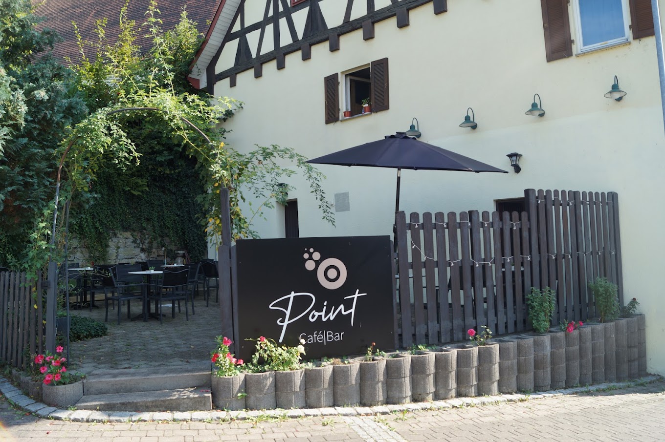 Außenansicht des Point Cafe Bar mit Logo-Schild und Biergarten in der Winnender Straße 2 in Schwaikheim